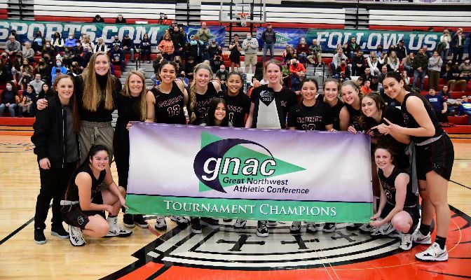 The Central Washington women's basketball team celebrates with the GNAC Championships trophy after defeating Western Washington 57-46. Photo by Ron Smith.