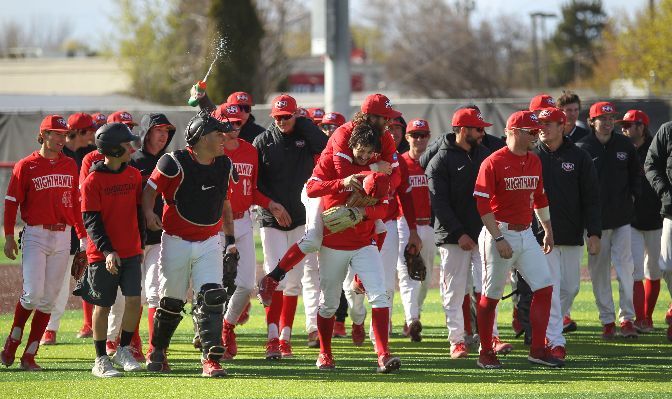 Northwest Nazarene teammates celebrate with Haden Keller (center, holding hat) after Keller threw the sixth no-hitter in GNAC history in a 3-1 victory on Saturday against Central Washington.