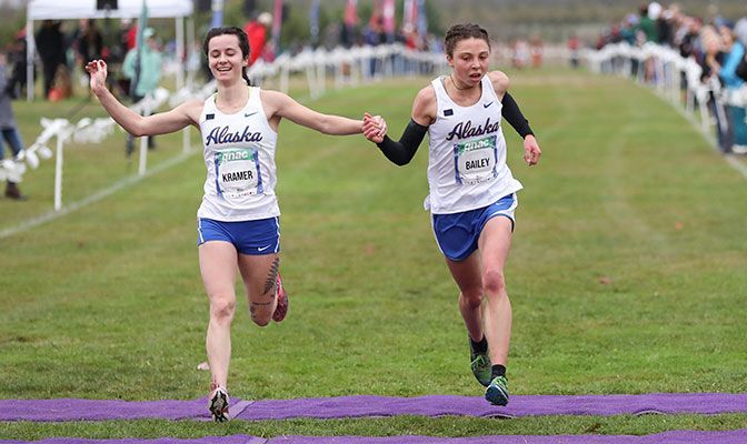 Kendall Kramer (left) and Naomi Bailey join hands in crossing the finish line first and second for Alaska. Kramer was the winner in 20:37 while Bailey clocked 20:37.1. Photo by Amanda Loman.