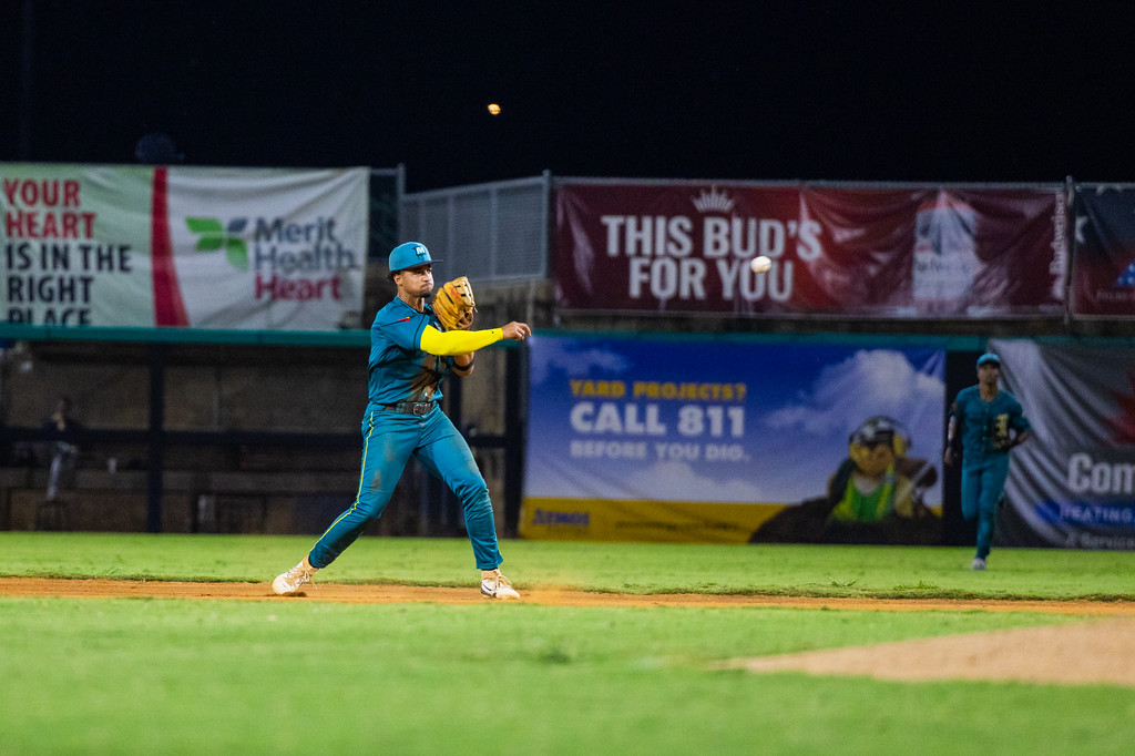 Mississippi Mud Monsters infielders in front of outfield wall signs at Trustmark Park