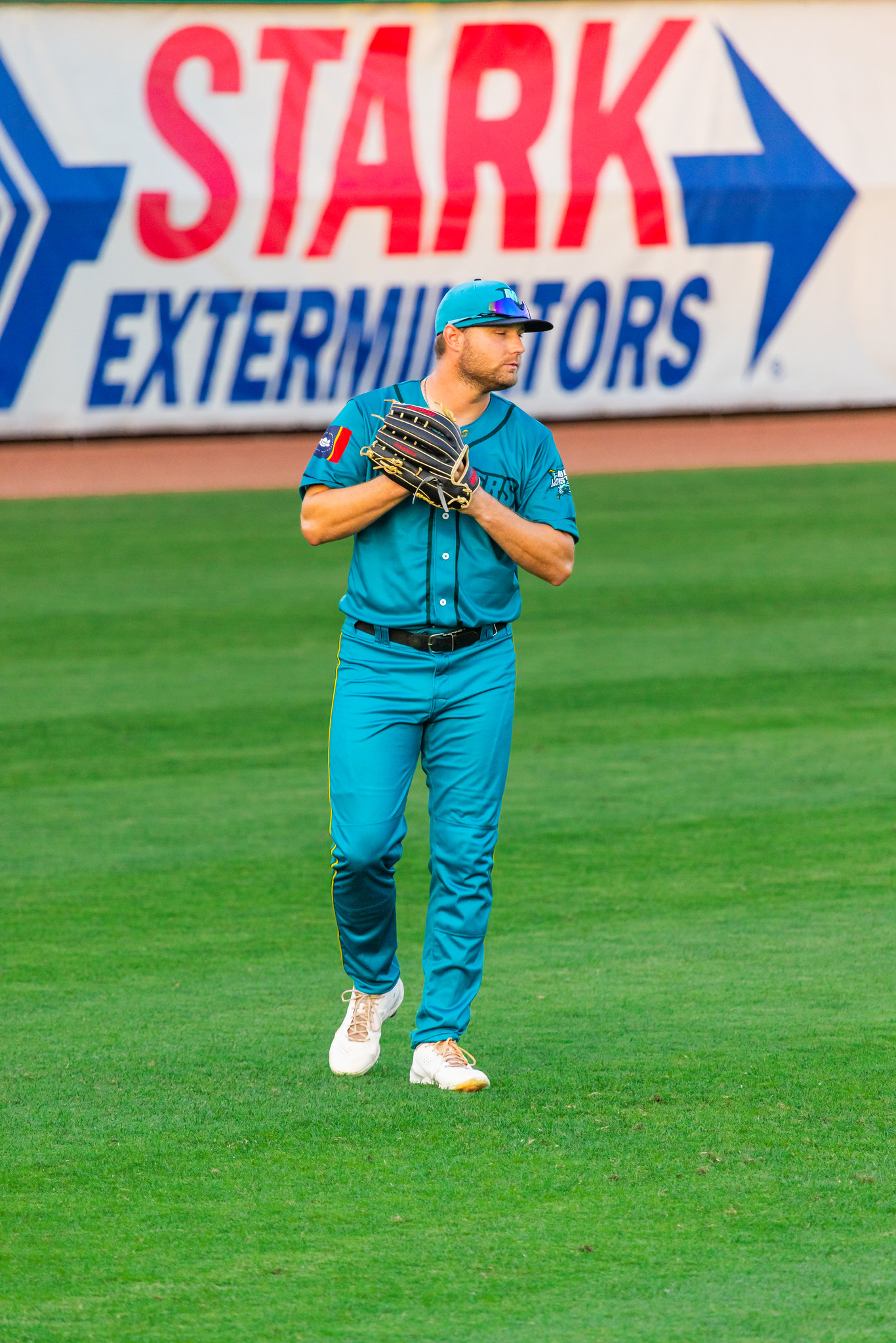 Mississippi Mud Monsters player in front of outfield wall signage during the season opener at Trustmark Park